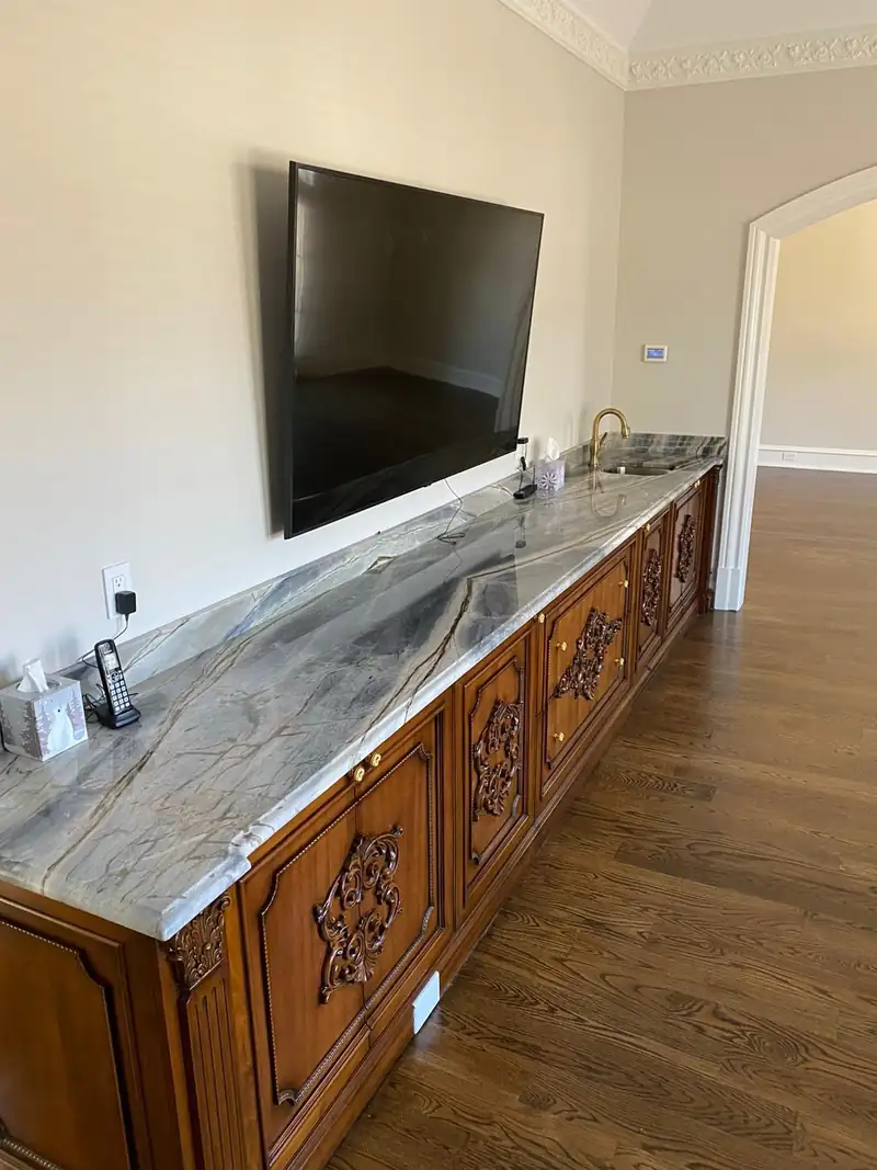 Blue veined stone top on a carved wood media console – installed by Beltway Countertops in Leesburg, VA