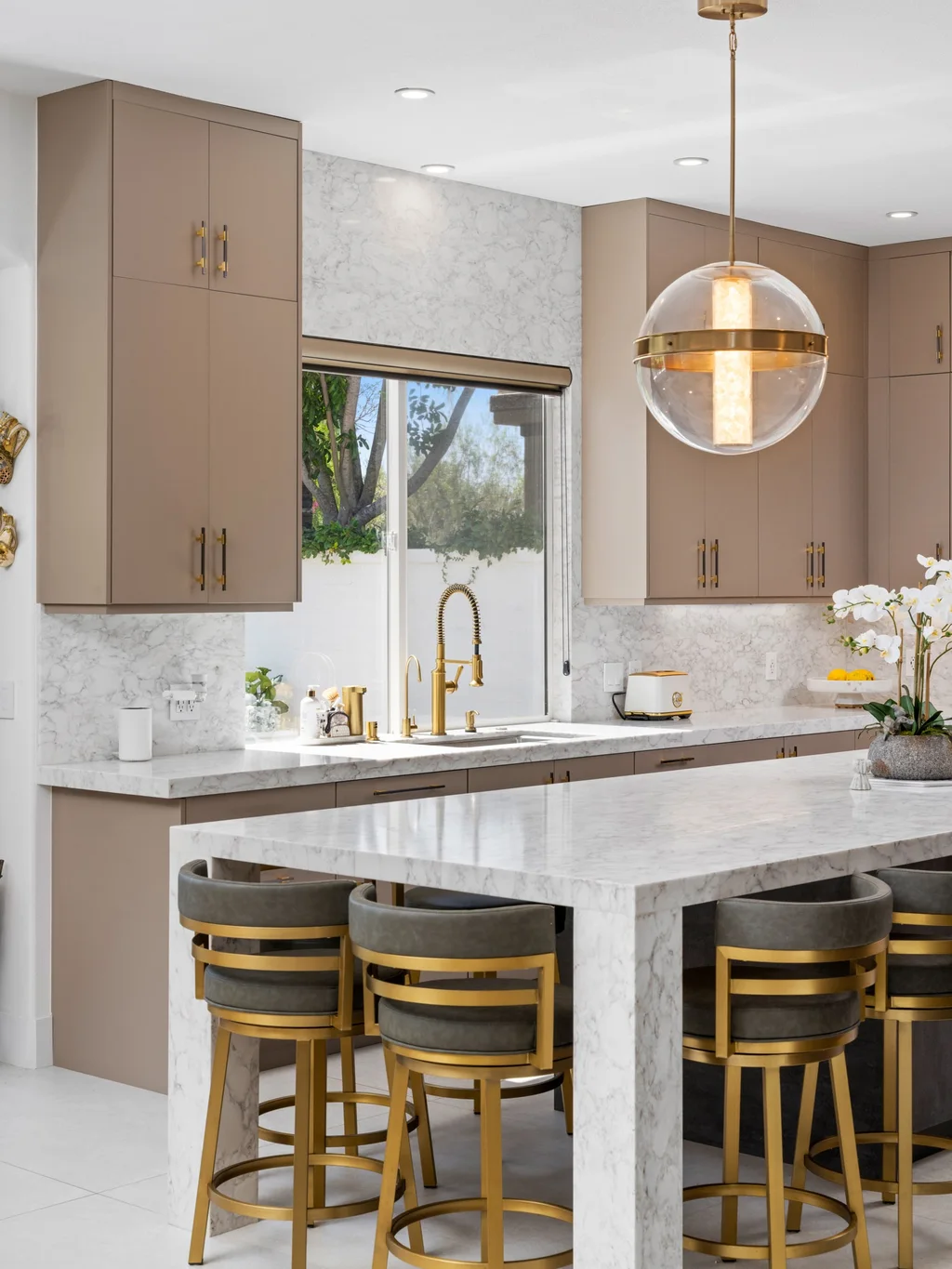 Calacatta Ocellio quartz waterfall island and full-height backsplash with taupe cabinets, installed by Beltway Countertops in Herndon, VA
