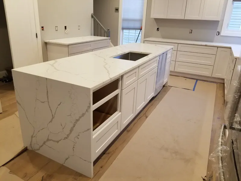 Calacatta quartz waterfall island in a new white kitchen – installed by Beltway Countertops in Ashburn, VA