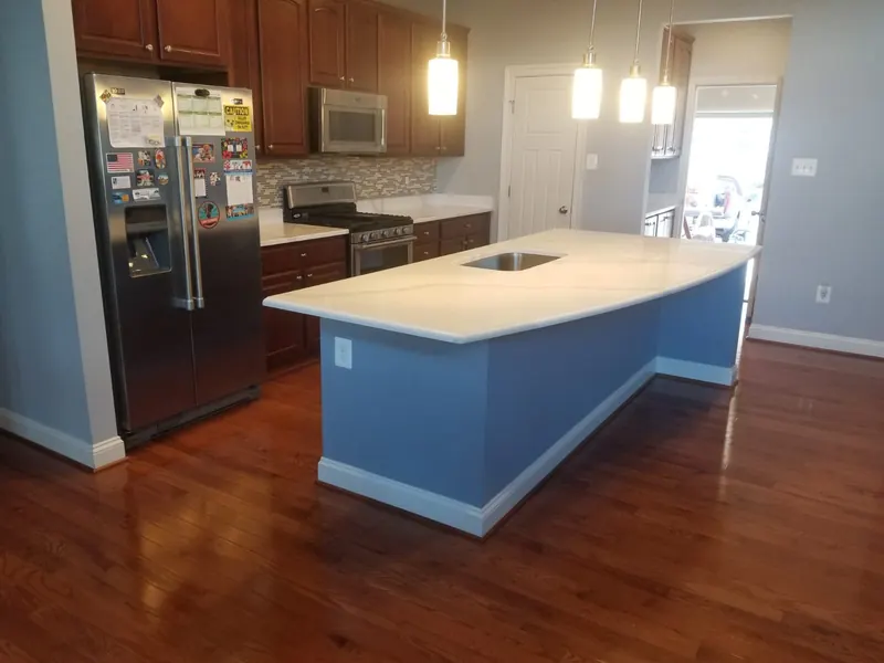 Curved white quartz island with an undermount sink – installed by Beltway Countertops in Reston, VA