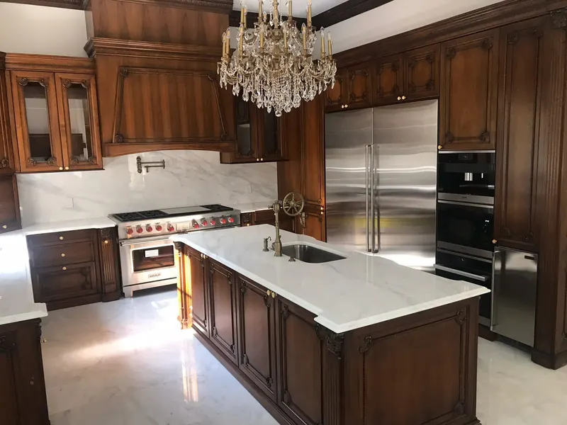 White marble-look countertops and full-height backsplash with walnut cabinets – installed by Beltway Countertops in Leesburg, VA