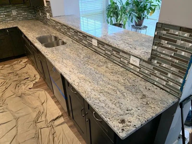White granite countertops with a glass mosaic backsplash – installed by Beltway Countertops in Reston, VA