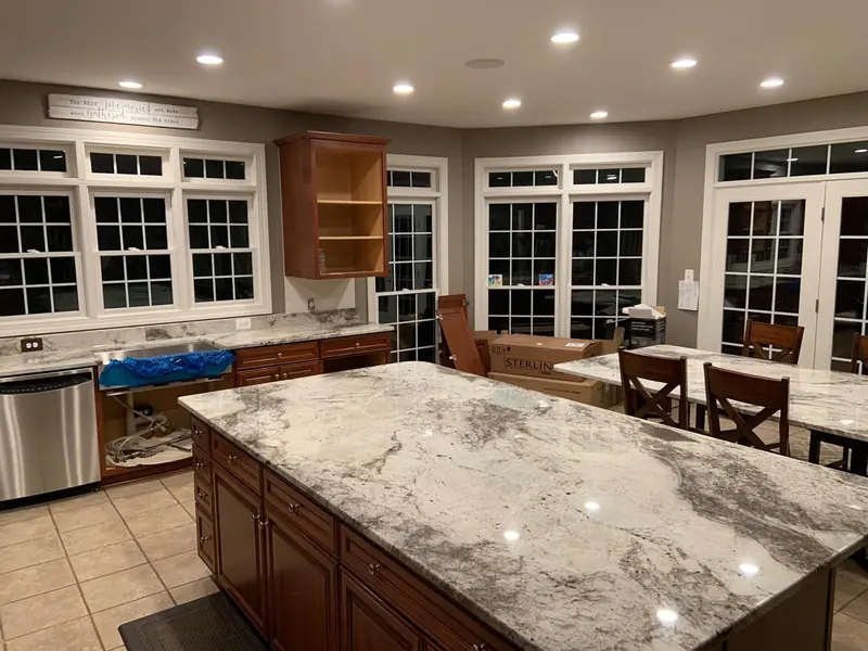 White and gray granite kitchen island with cherry cabinets – installed by Beltway Countertops in Chantilly, VA