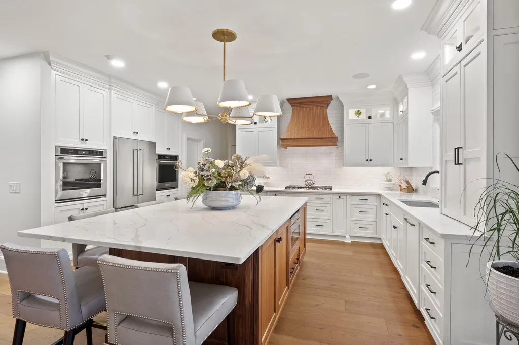 White quartz countertops on a walnut kitchen island with white shaker cabinets, installed by Beltway Countertops in Reston, VA