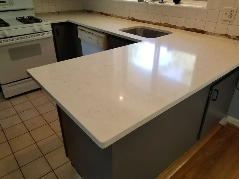 White quartz peninsula with gray cabinets – installed by Beltway Countertops in Herndon, VA